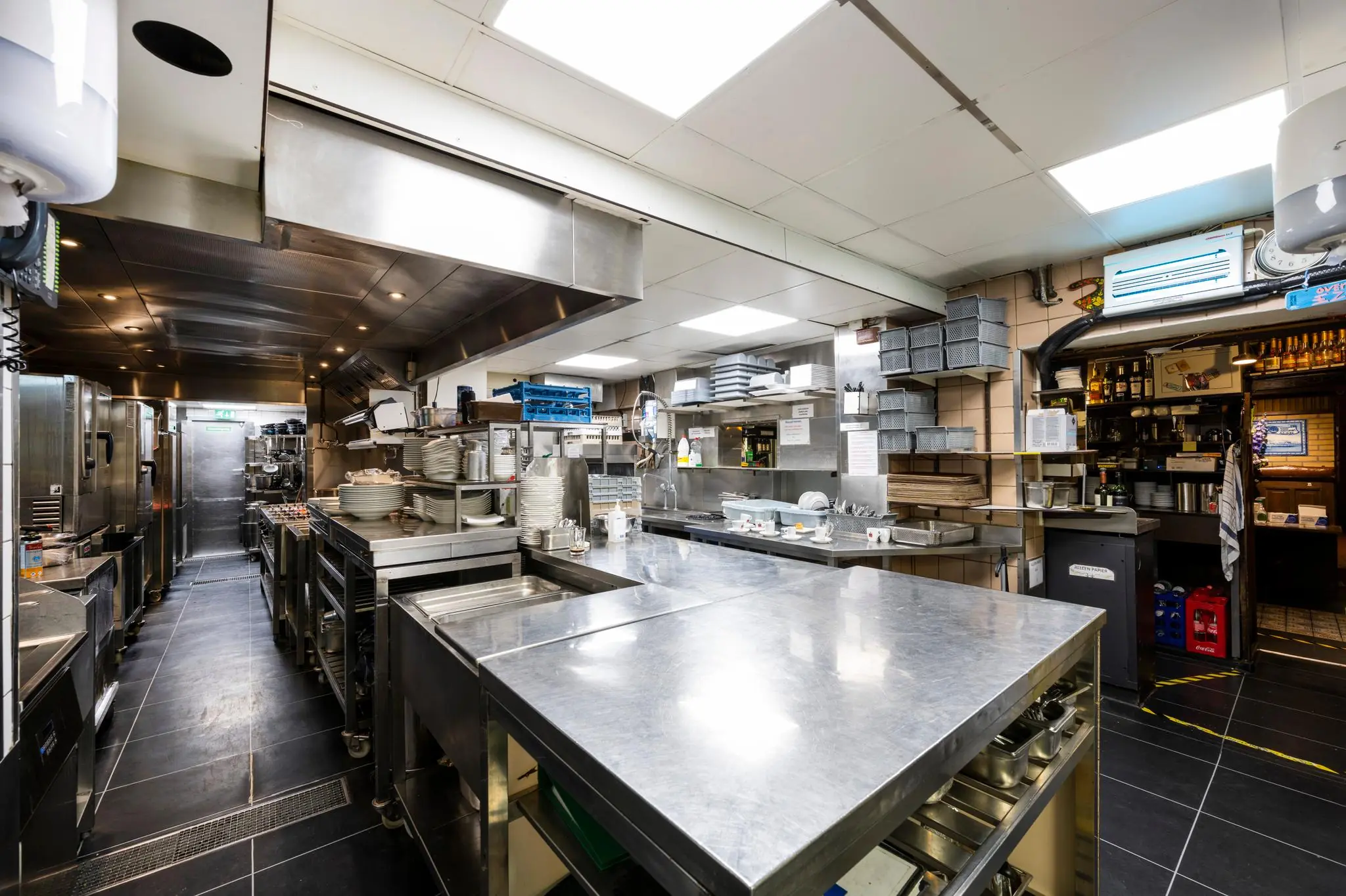 Professionele, moderne restaurantkeuken aan de Nieuwezijds Voorburgwal met roestvrijstalen werkbladen en keukengerei.